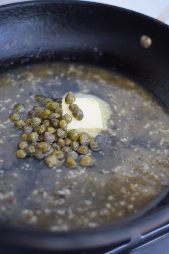 Making a lemon caper sauce in a skillet.