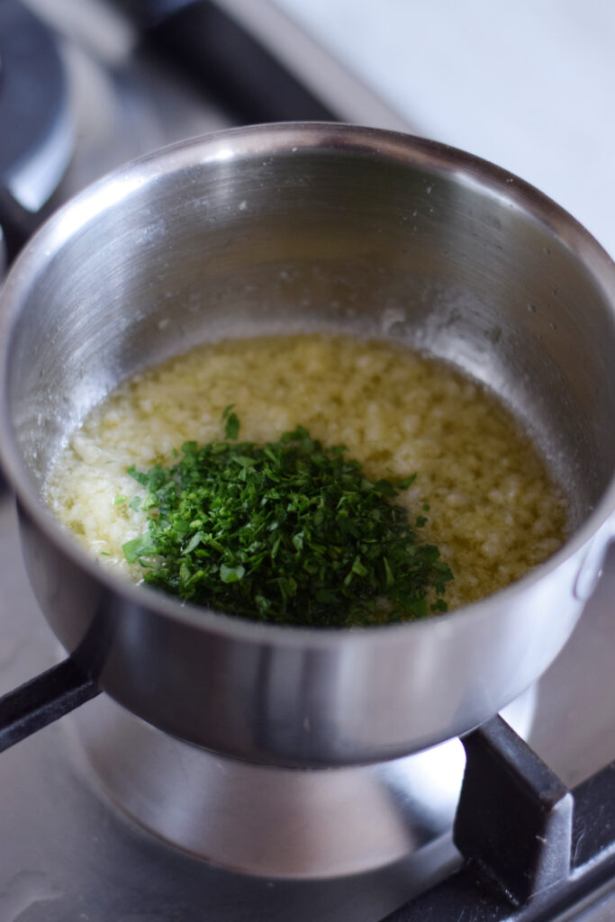 Adding parsley to garlic butter.