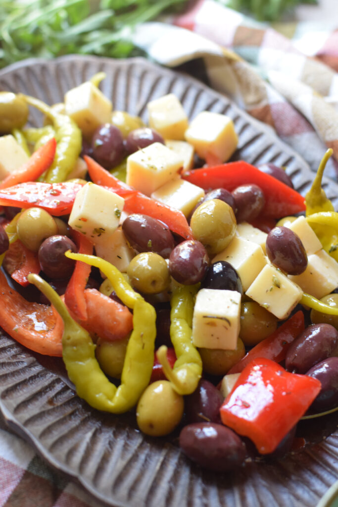 Mix of olives and cheese on a wooden plate.