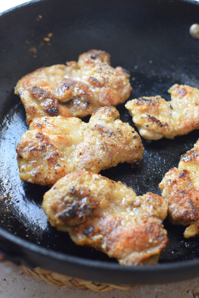 Cooking chicken in a skillet.