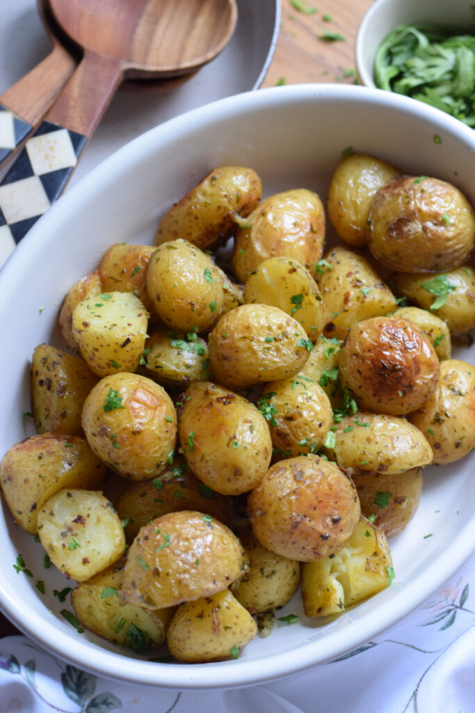 Roasted potatoes in a white serving dish.