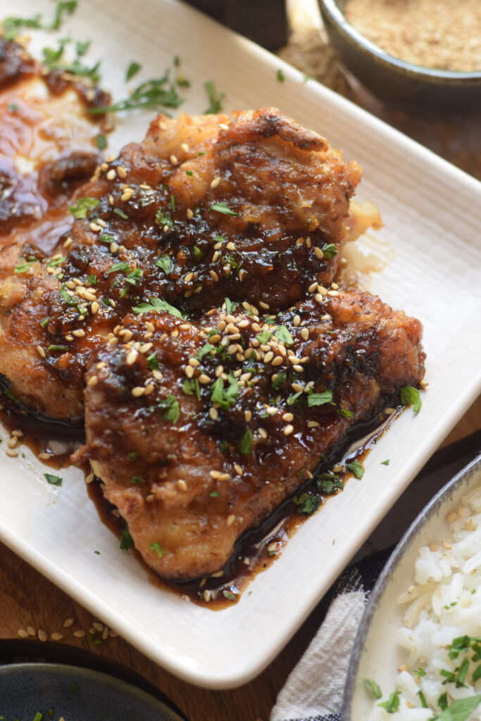 Close up of garlic soy chicken on a white plate.