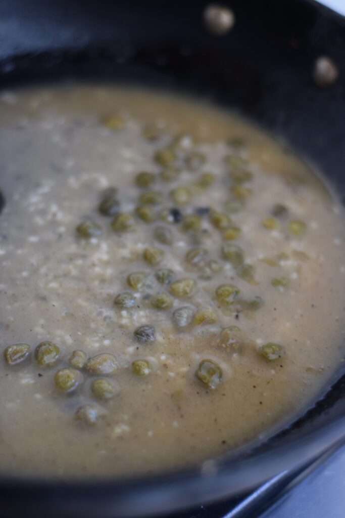 Making a lemon caper sauce in a skillet.