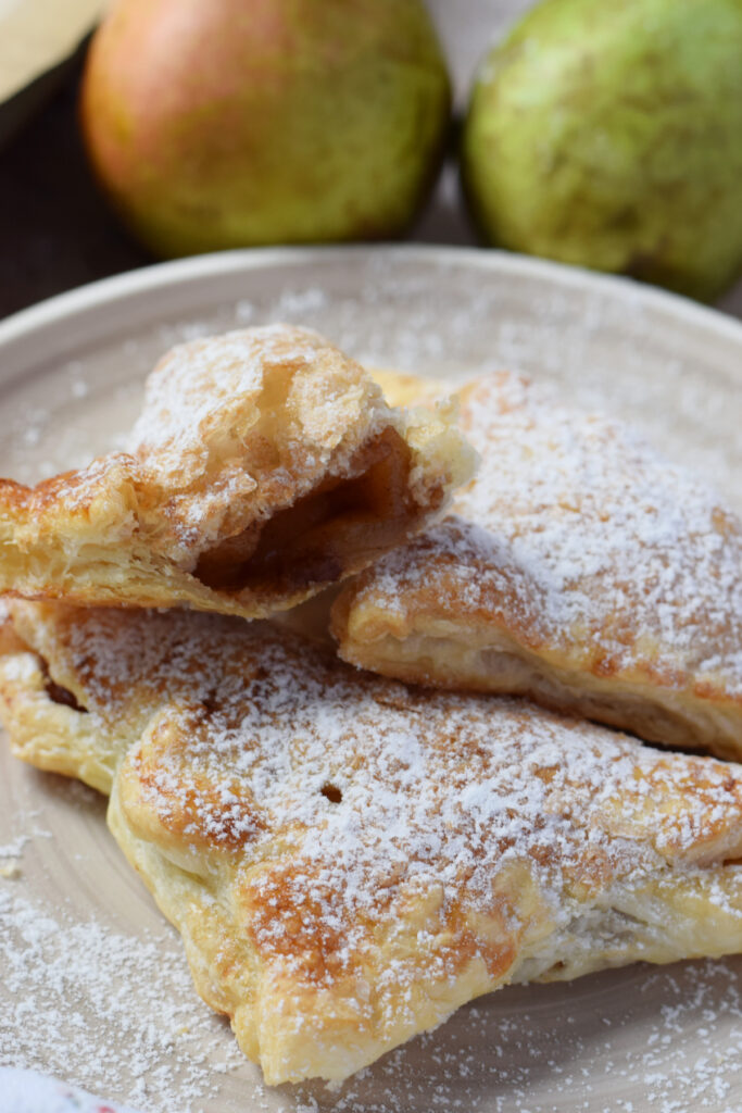 Close up of caramelized pear turnovers on a plate.