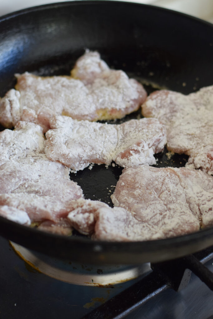 Cooking chicken in a skillet.