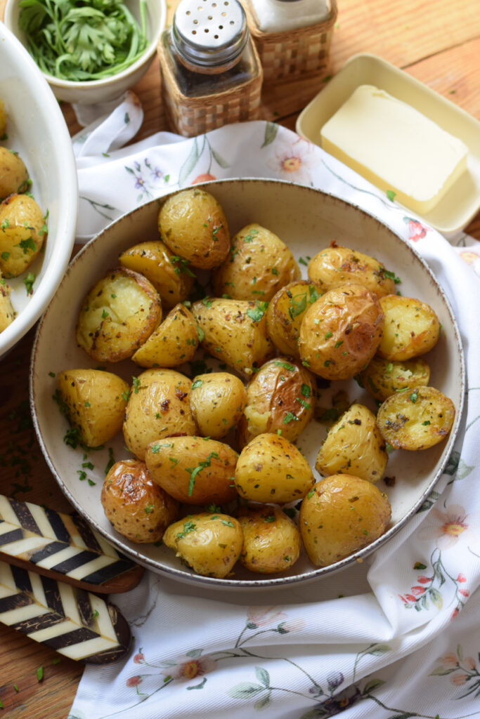 Garlic butter potatoes in a white serving dish.