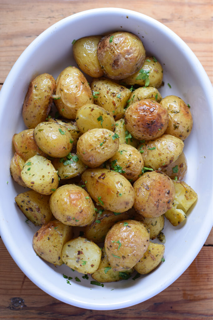 Garlic roasted potatoes in a white bowl.