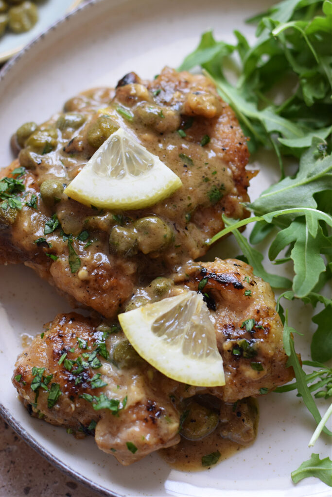 Close up of lemon caper chicken on a plate.