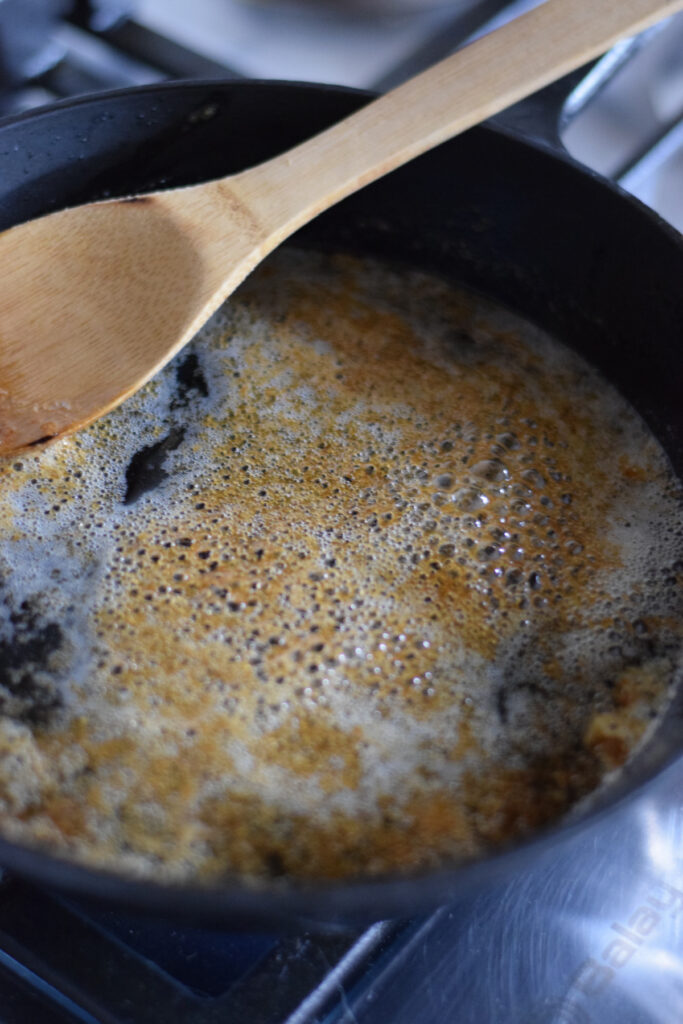 Cooking brown sugar and butter in a cast iron skillet.