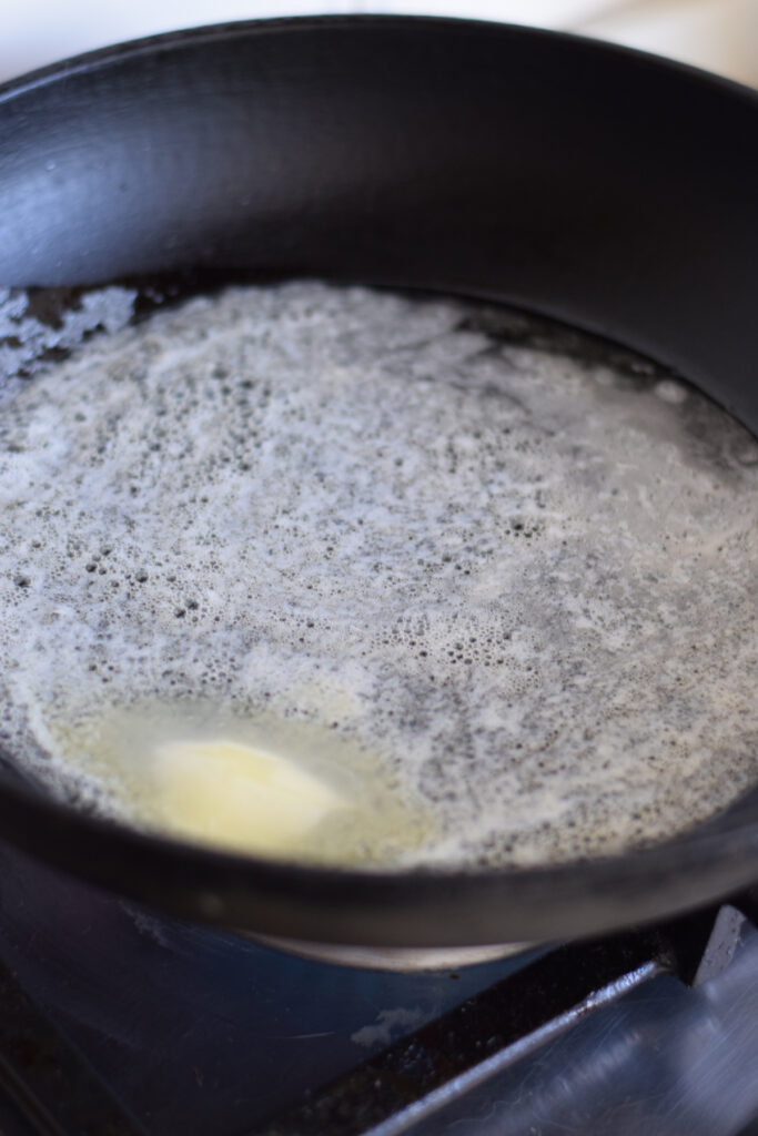 Melting butter in a large skillet.