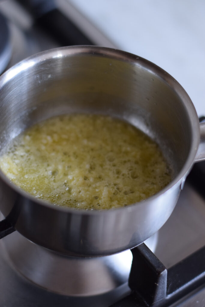 Making garlic butter in a small saucepan.