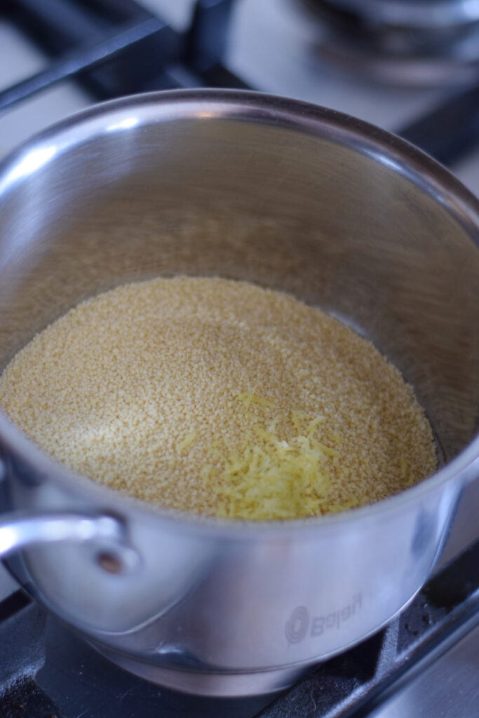 Couscous and lemon in a saucepan.