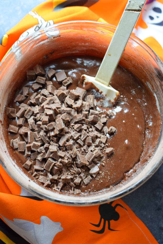 Adding chocolate chunks to cookie batter.