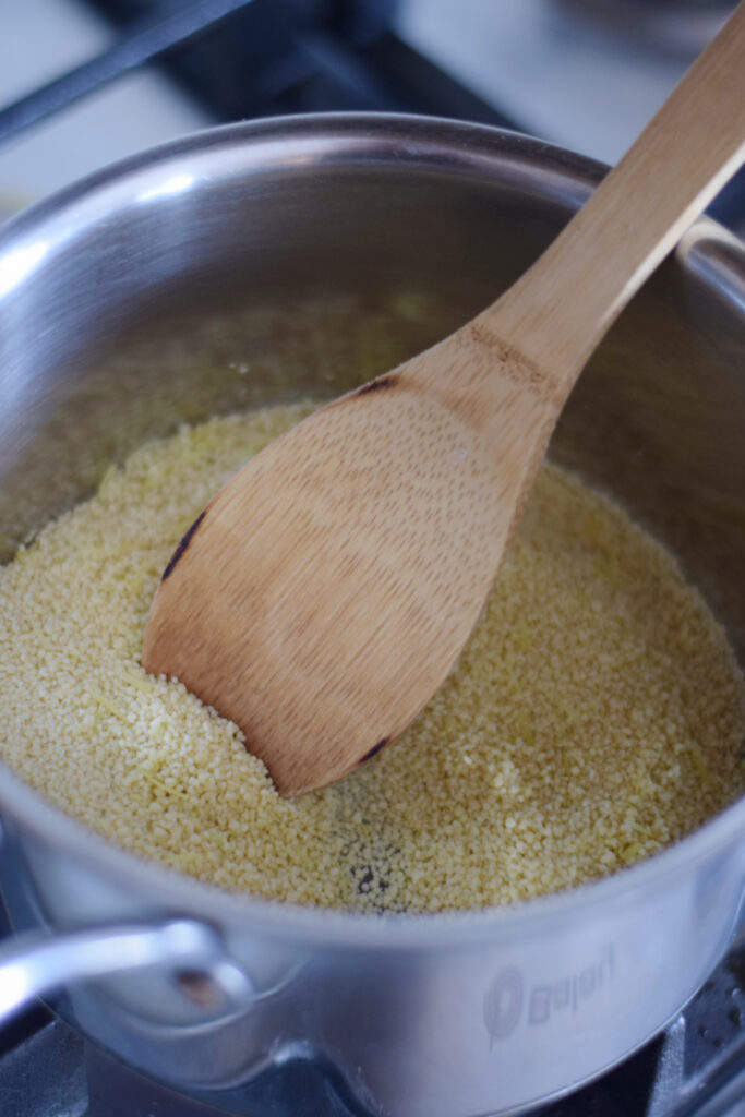 Dry frying couscous in a saucepan.