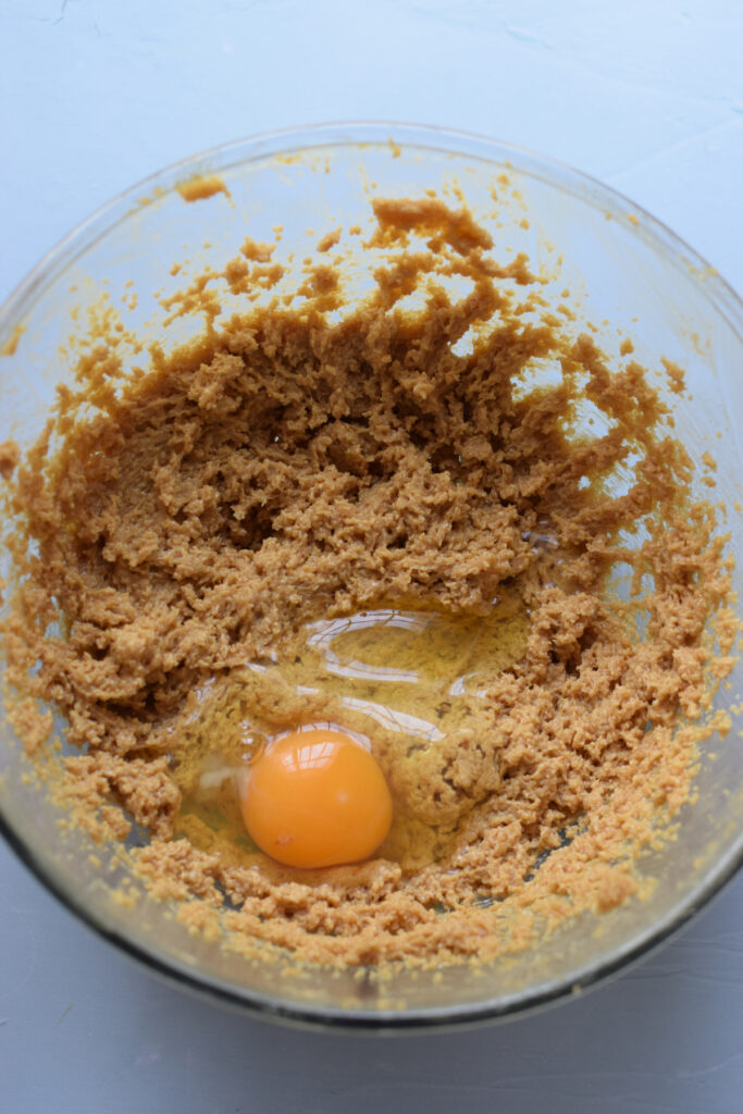 Adding eggs to muffin batter.