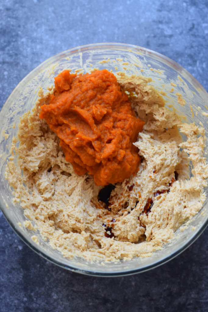 Adding pumpkin puree to cookie dough.