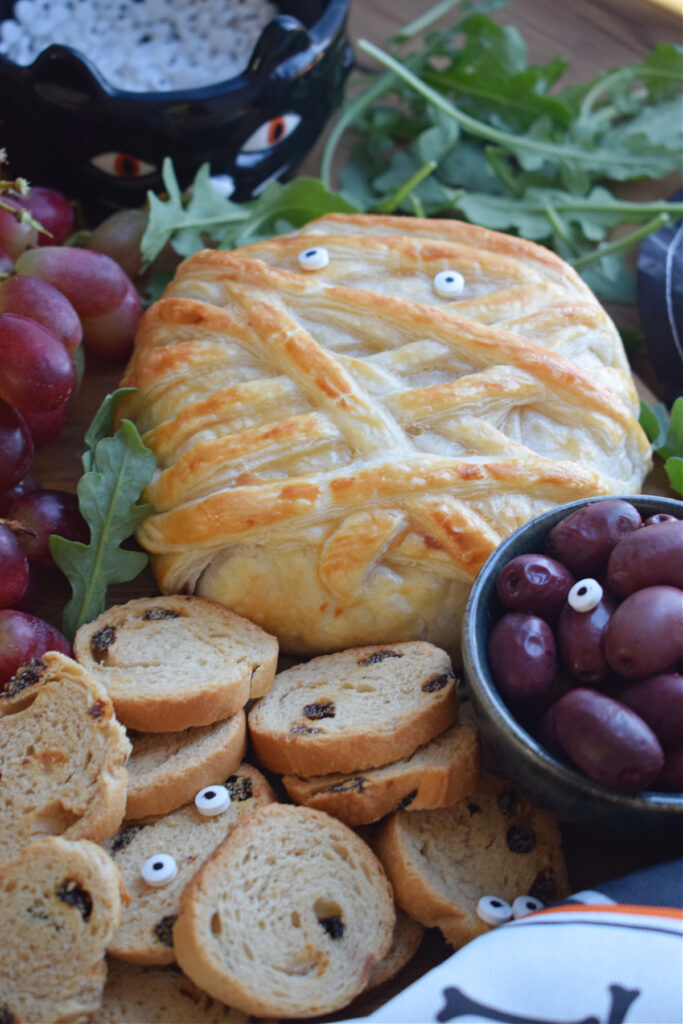 Halloween baked brie with crackers, cheese and olives.