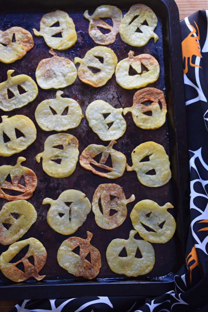 Baked potato slices on a baking tray.