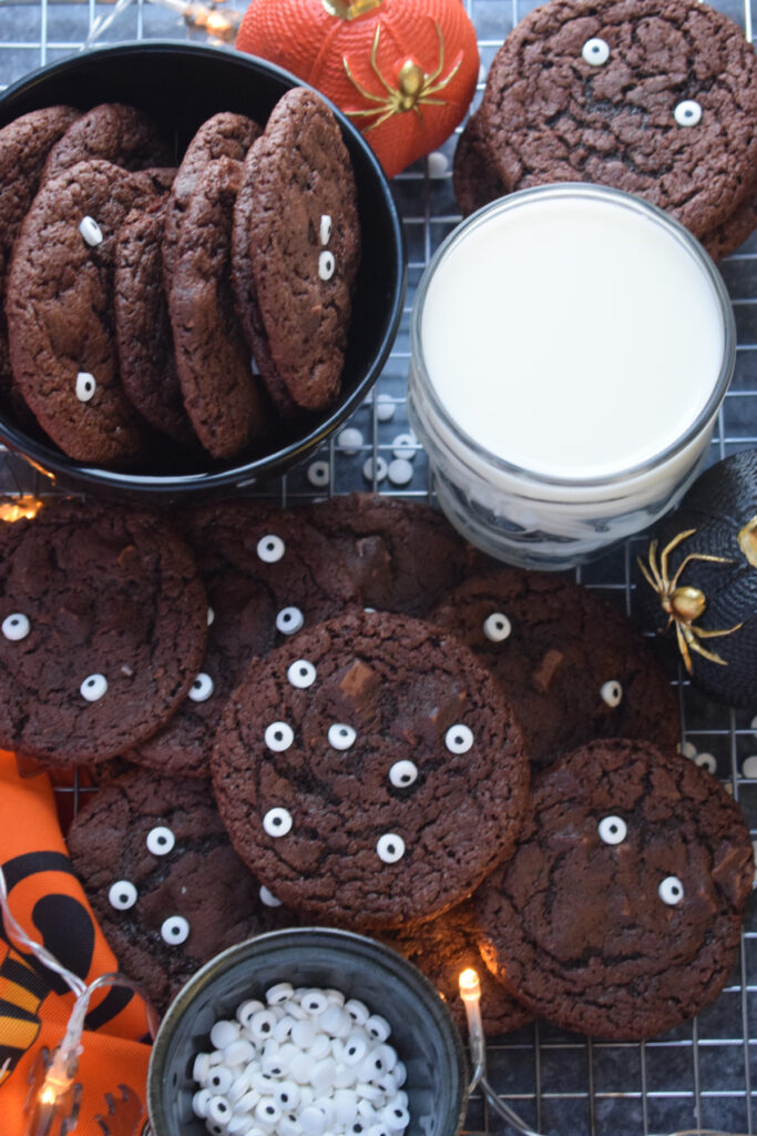 Halloween cookies with decorations and a glass of milk.