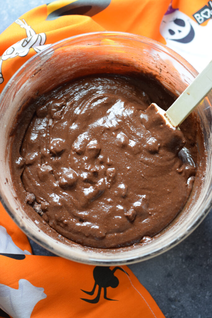 Chocolate cookie dough in a glass bowl.