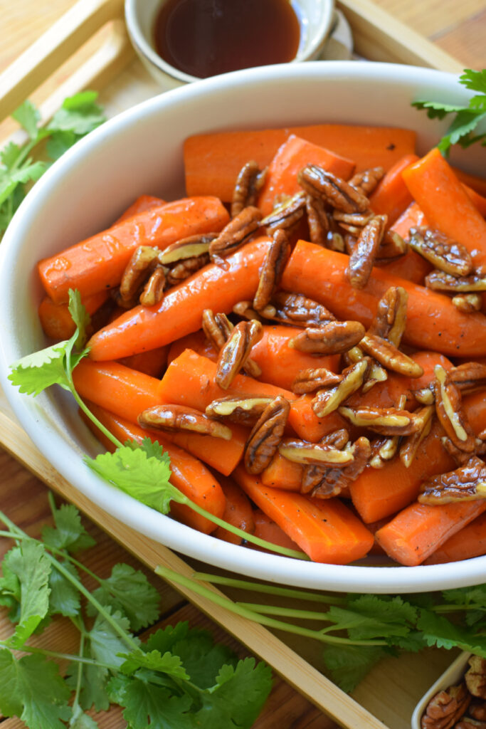 Roasted carrots in a white serving dish.