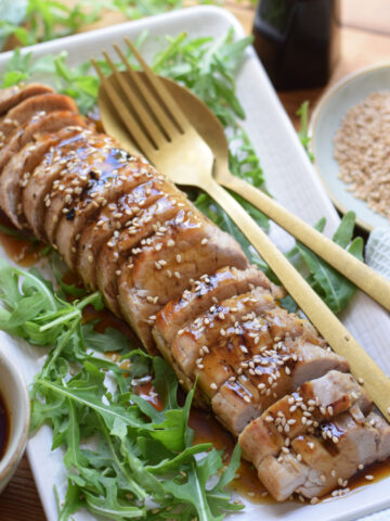 Soy glazed pork tenderloin on a white plate.