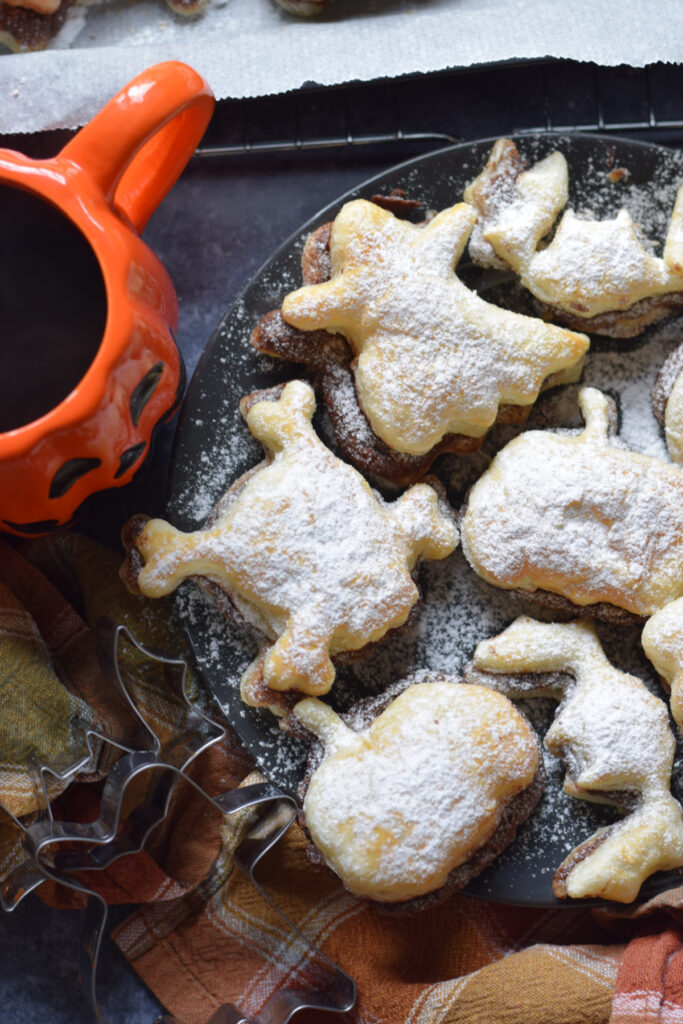 Nutella puff pastry shapes on a black plate.