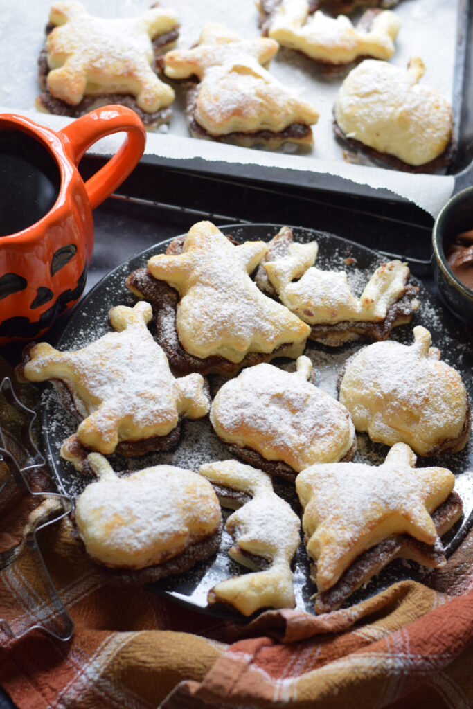 Halloween puff patsry shapes on a black plate.