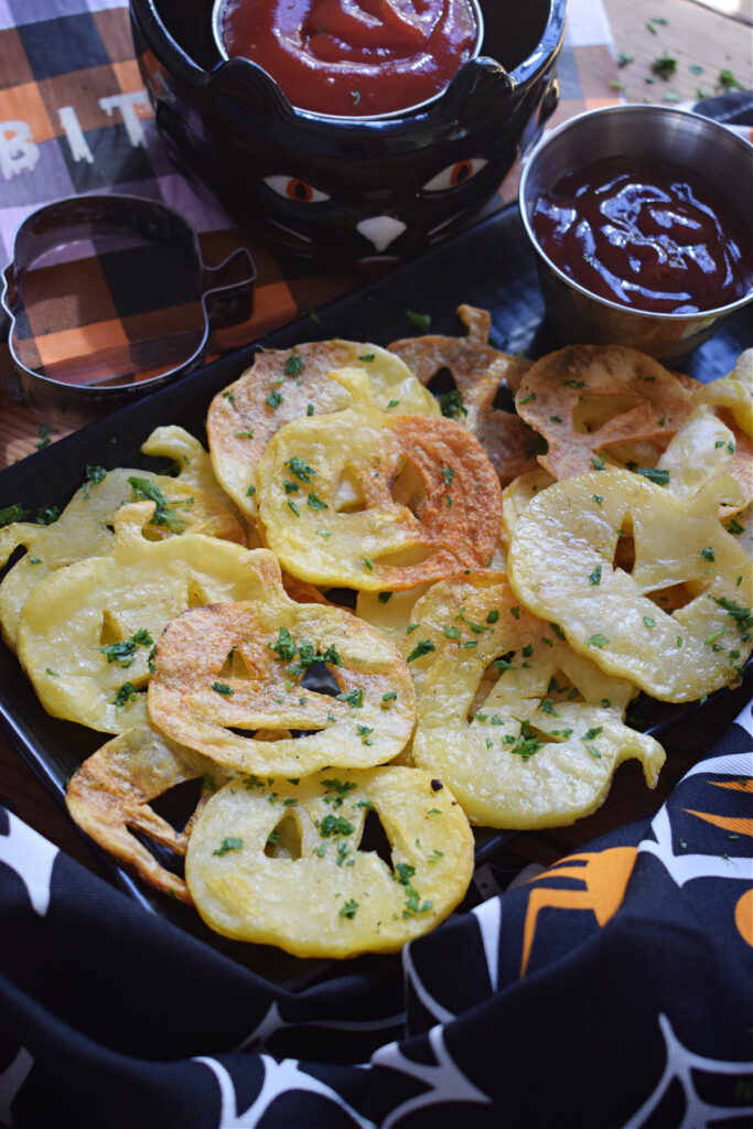 Pumpkin face potato chips on a plate.