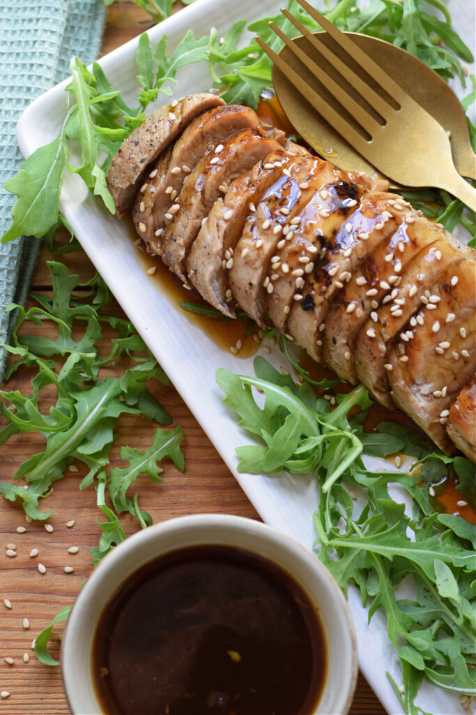 Close up of pork tenderloin with sauce.