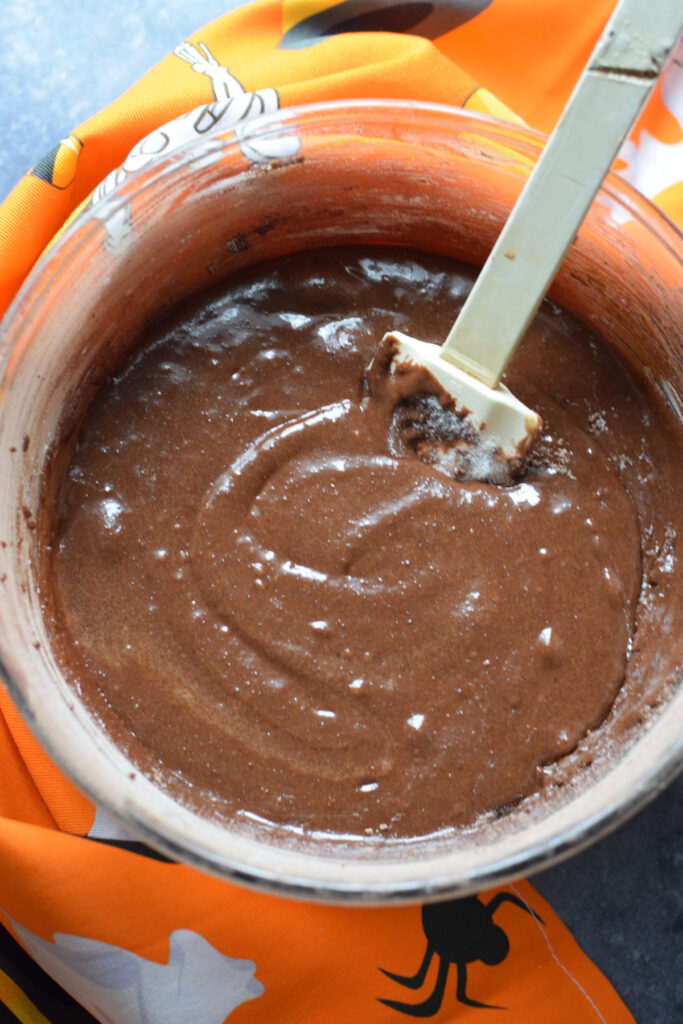 Chocolate cookie batter in a glass bowl.