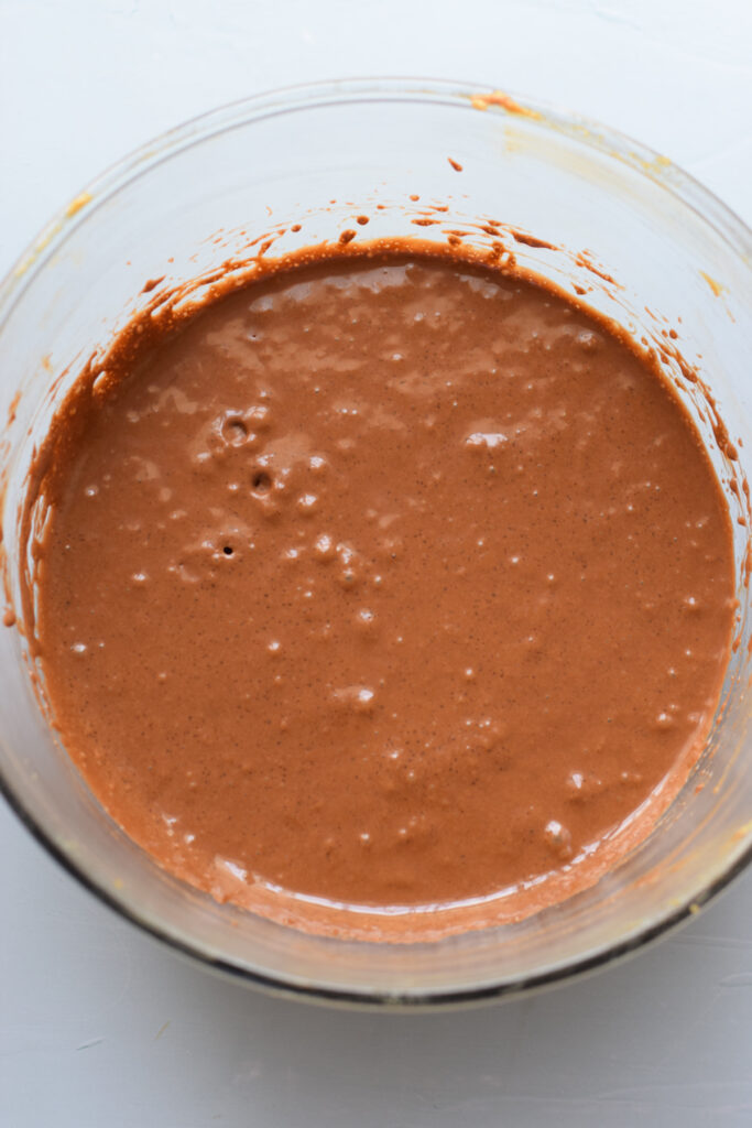 Mixing in melted chocolate to muffin batter.