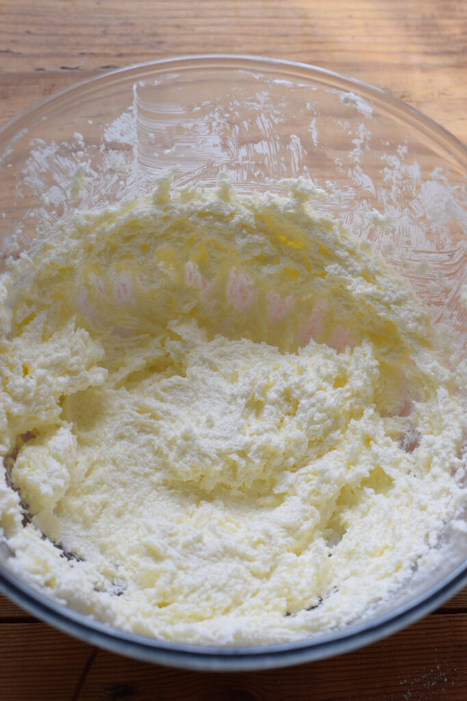 Mixed butter and sugar in a glass bowl.