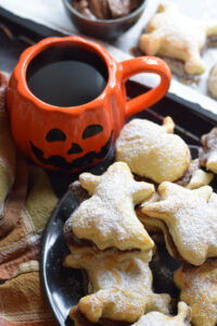 Halloween puff pastry shapes on a plate with coffee.