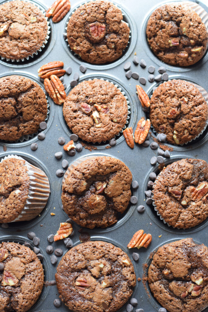 Chocolate pecan muffins in a muffin tin.