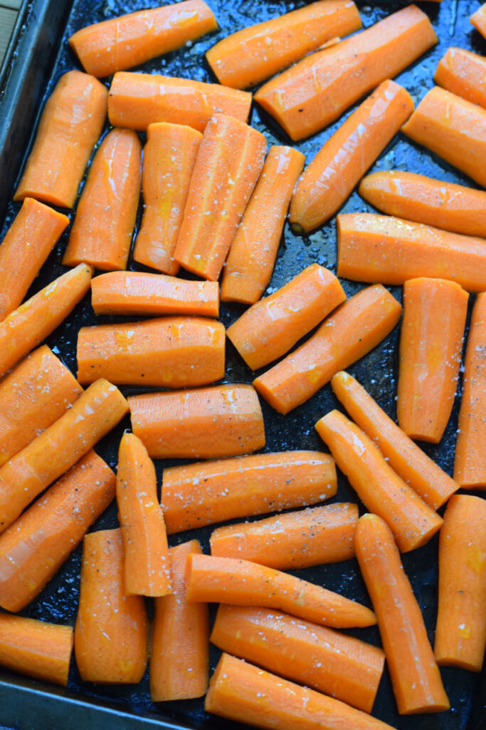 Ready to roast carrots on a baking tray.