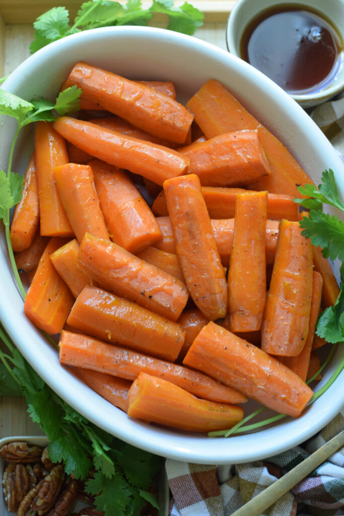 Roasted carrots in a white serving dish.