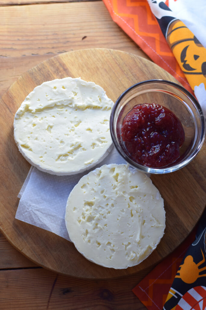 Cheese wheel with jam in a bowl.