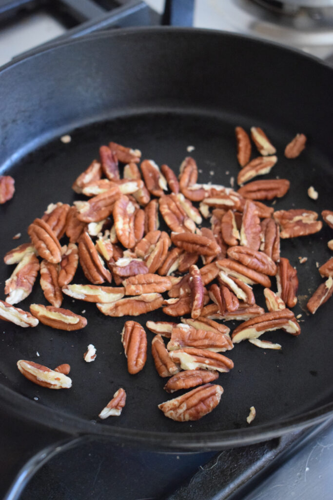 Toasted pecans in a skillet.