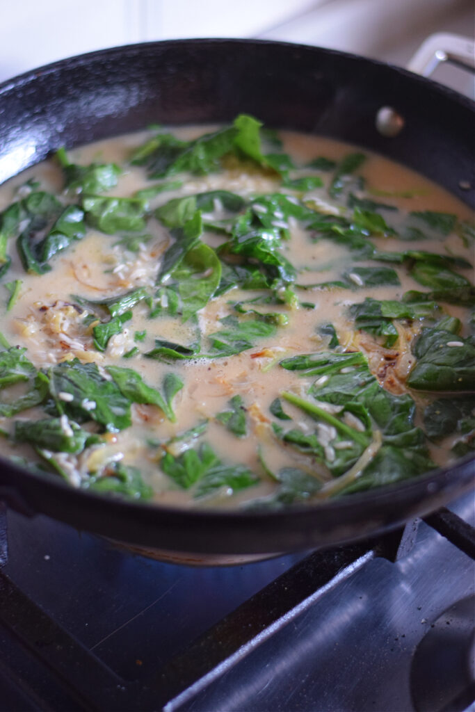 Making spinach and rice in a cast iron skillet.