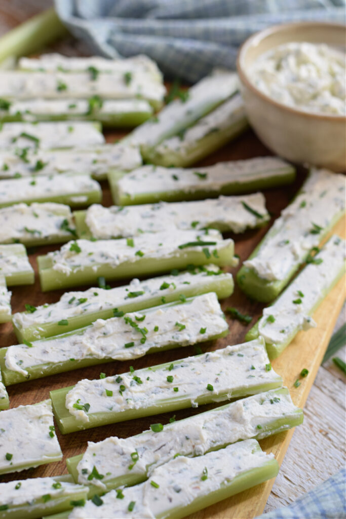 Stuffed celery pieces on a wooden board.