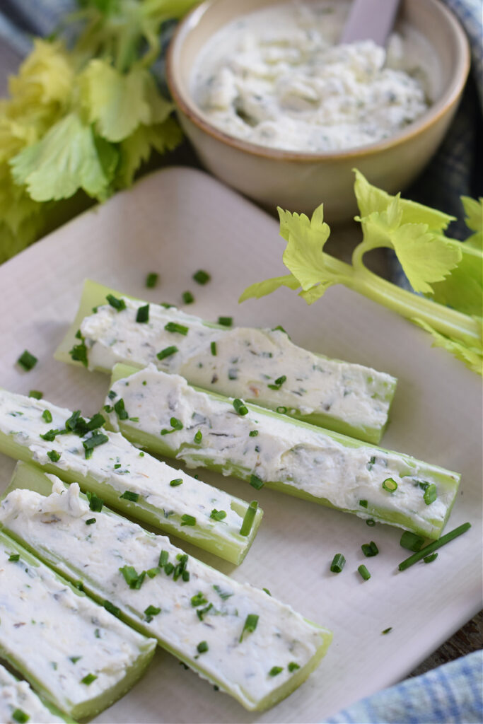 Cream cheese stuffed celery on a plate.