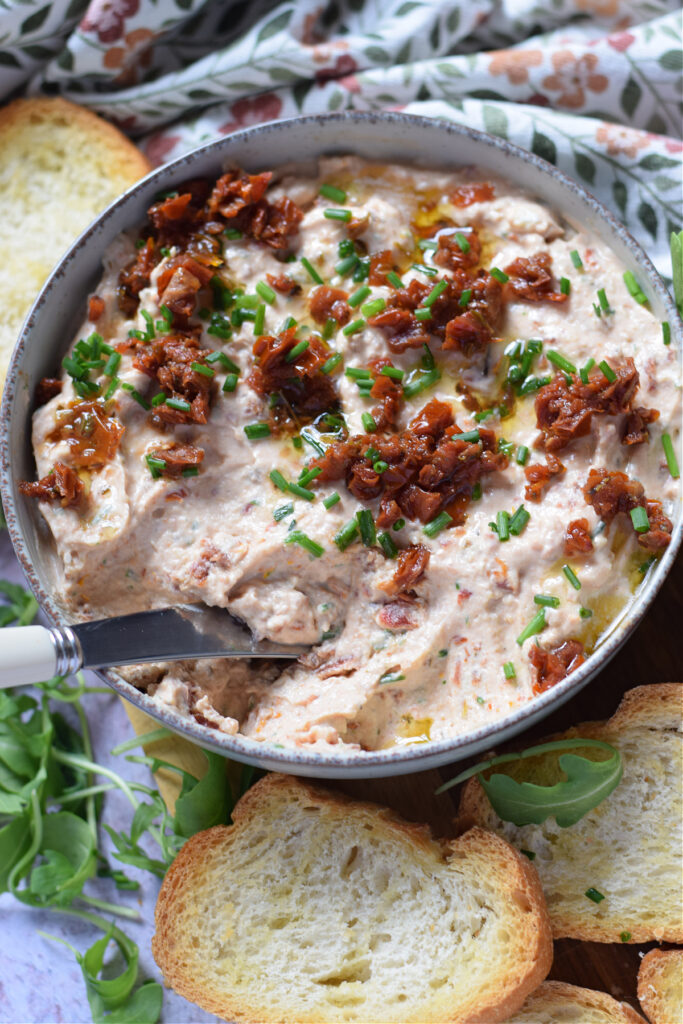 Serving sun dried tomato dip.