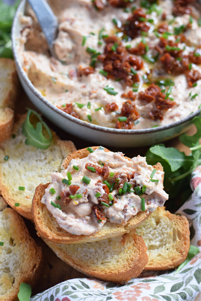 Sun dried tomato dip on a baguette slice.