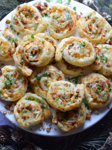 Goat cheese puff pastry appetizers on a serving plate.