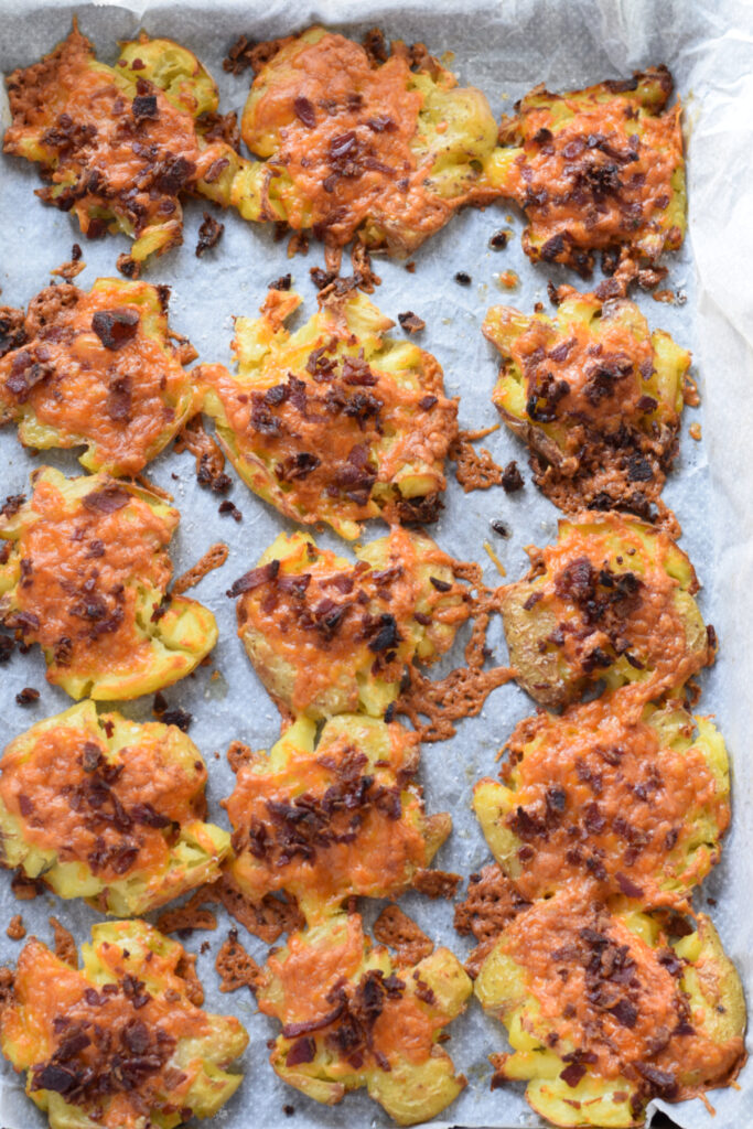 Baked smashed potatoes on a baking tray.