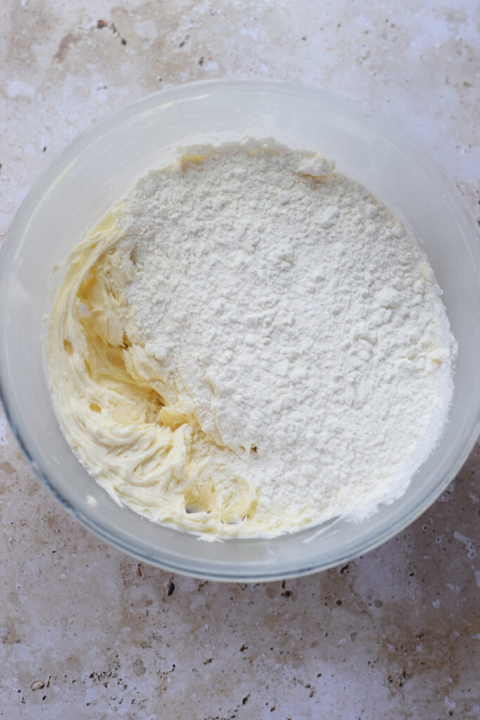 Adding flour to cookie dough.