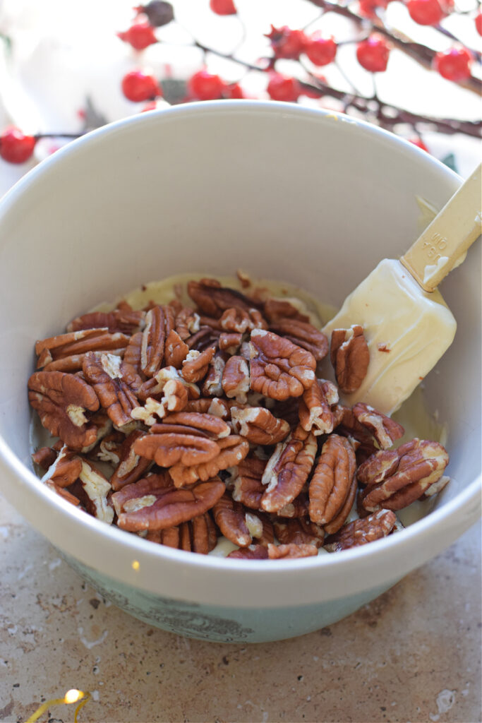 Combined pecans and white chocolate in a bowl.