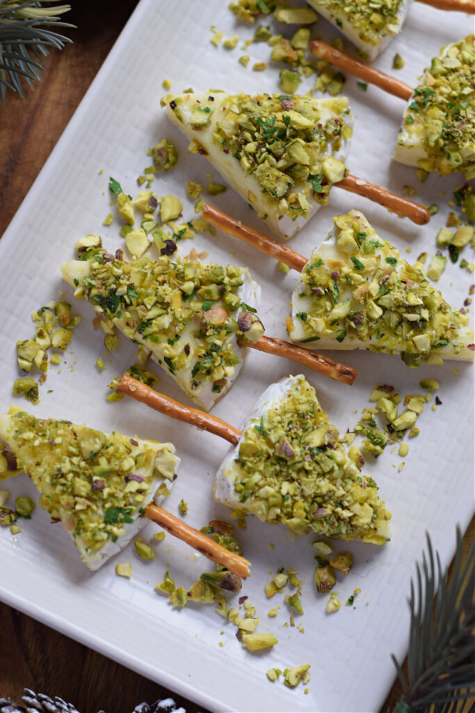 Mini christmas tree cheese appetizers on a white plate.