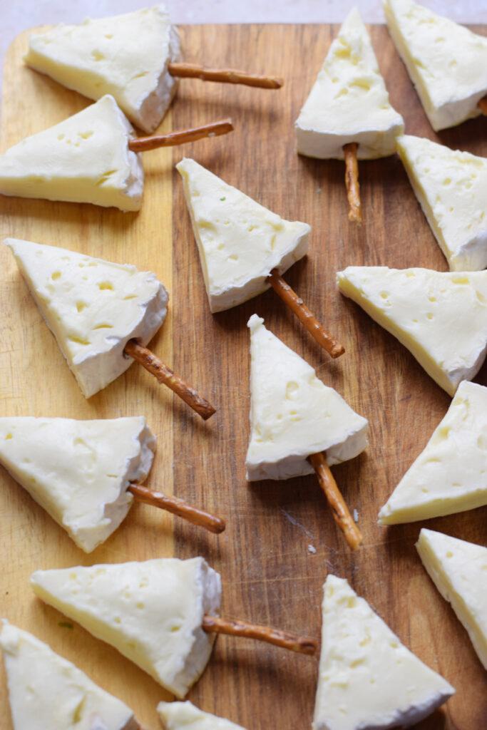 Cheese cut into wedges on a board.